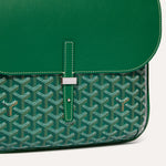Close up detail of green leather flap and metallic buckle on Goyardine messenger bag
